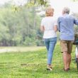 Elderly man and woman walking with a bike in a park